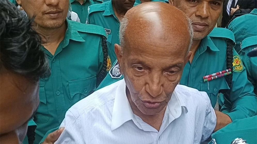 দেয়াল ঘেঁষে কাঠগড়ায় দাঁড়িয়ে ছিলেন কামাল আহমেদ মজুমদার